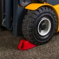 Oranžový plastový bezpečnostní zakládací klín pod kola - délka 21 cm, šířka 10 cm, výška 9 cm