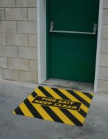 Černo-žlutá korundová protiskluzová podlahová páska s potiskem FLOMA Fire Exit Marker - délka 150 cm, šířka 100 cm